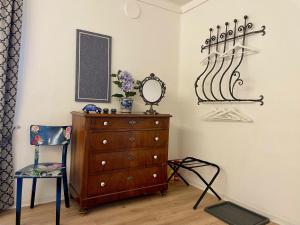 een kamer met een dressoir, een spiegel en een stoel bij 1912 - Blue Room - old town in Locarno