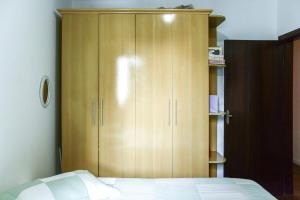 un armario de madera en un dormitorio con cama en Casa Compartilhada na Aclimação by BnbHost, en São Paulo