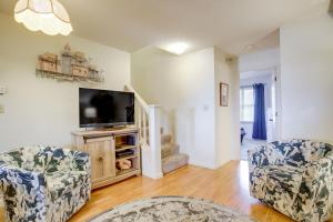 a living room with two chairs and a flat screen tv at Walk to Ocean City Beach Condo with Rooftop Deck in Ocean City