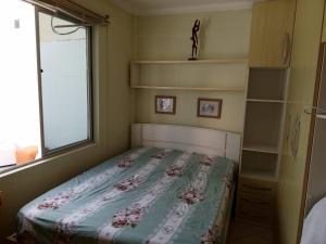 a bedroom with a bed with a floral quilt on it at Apartamento cobertura em balneário Camboriú in Balneário Camboriú