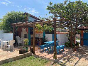 a patio with a blue table and a pergola at CASA DA BARRA- Suítes privativas em Saquarema in Saquarema