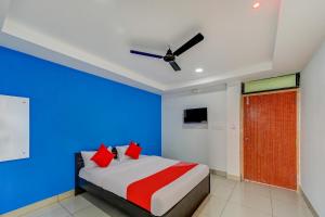 a bedroom with a bed with blue and red pillows at SPOT ON Hotel Utrishree in Khandagiri
