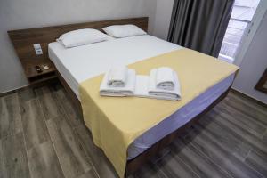 Una habitación de hotel con una cama con toallas. en Nikolaidis Apartments, en Nea Plagia