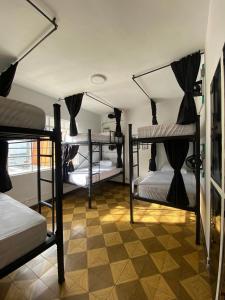 a room with four bunk beds and a tiled floor at La Palmera Hostel in Cali