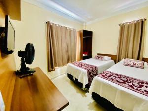 a room with two beds and a camera in it at Hotel Camocim in Camocim