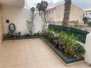 un jardín con flores y plantas junto a un edificio en Beach Townhouse - Murdeira Village en Beirona