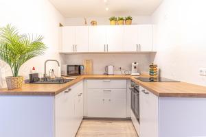 a white kitchen with wooden countertops and white cabinets at Apartment Leverkusen in Leverkusen