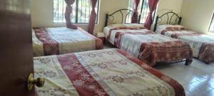 Un grupo de 4 camas en una habitación en HOTEL MONTALVO, en Tezontepec de Aldama