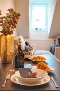 - une table avec deux assiettes de nourriture et des verres à vin dans l'établissement Apartmán Amici, à Karlovy Vary