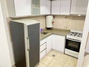 een kleine keuken met witte kasten en een koelkast bij O’Higgins D 5 in Godoy Cruz