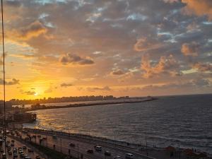 a sunset over a body of water with a bridge at Welcome sea view - families only in Alexandria