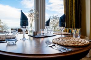 a wooden table with wine glasses and plates on it at Weston Hotel in Scarborough