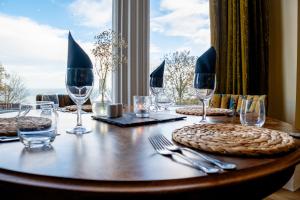 uma mesa de madeira com copos de vinho e pratos em Weston Hotel em Scarborough