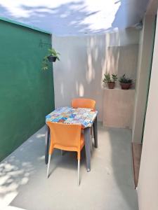 uma mesa e duas cadeiras sentadas num pátio em Suítes em casa de família com entrada independente em Ubatuba
