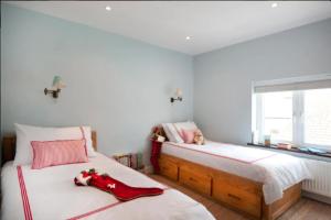 a bedroom with two beds with red shoes on them at The Boat House in Aldeburgh
