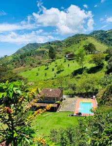 ein Haus auf einem grünen Hügel mit Pool in der Unterkunft Barbosa Finca el paraíso in Barbosa