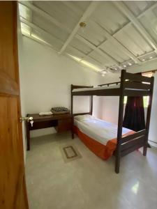 1 Schlafzimmer mit 2 Etagenbetten und einem Schreibtisch in der Unterkunft Barbosa Finca el paraíso in Barbosa