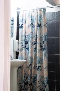 uma casa de banho com uma cortina de chuveiro e um lavatório em La Palmera Hostel em Cali