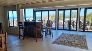 sala de estar con mesa y sillas y balcón en Kidds beach house, en Kiddʼs Beach
