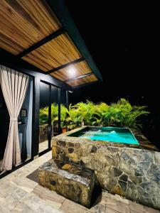 una piscina en medio de una casa por la noche en Arrayán Glamping, en San Gil