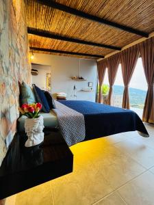 um quarto com uma cama com um vaso de flores em Arrayán Glamping em San Gil