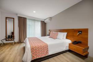 Ένα ή περισσότερα κρεβάτια σε δωμάτιο στο Leblón Suites Hotel