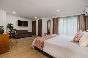 Ένα ή περισσότερα κρεβάτια σε δωμάτιο στο Leblón Suites Hotel