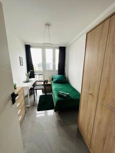 a bedroom with a green bed and a desk at Warsaw City Center Rooms in Warsaw