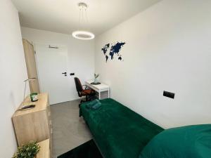 een slaapkamer met een groen bed en een bureau bij Warsaw City Center Rooms in Warschau