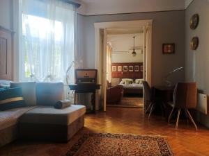 een woonkamer met een bank en een kamer met een slaapkamer bij Parkside Large Modern Garden View Apartment in Boedapest
