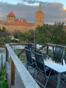 a table and chairs on a deck with a view of a castle at Ferienhaus Burgblick in Stadtschlaining in Stadtschlaining