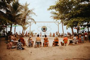 un grupo de personas sentadas en sillas en la playa en Viajero Tayrona Hostel & Ecohabs, en Buritaca