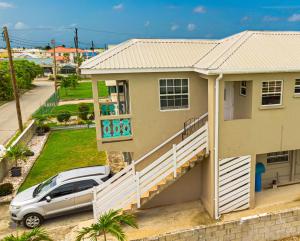 a house with a car parked in front of it at Cozy Modern Upstairs 2 Bed A/C Apt Near 2 Everything in Saint Philip