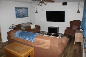 een woonkamer met 2 banken en een flatscreen-tv bij Beautiful Ranch Home Between Virginia Beach and Norfolk in Virginia Beach