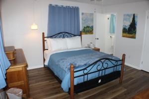Schlafzimmer mit einem Bett mit blauer Decke in der Unterkunft Beautiful Ranch Home Between Virginia Beach and Norfolk in Virginia Beach