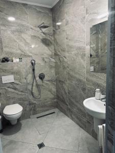 a bathroom with a shower and a toilet and a sink at Арт Мезонет Salem in Velingrad