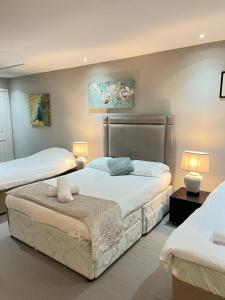 a bedroom with two beds and two lamps in it at Fulham suites in London