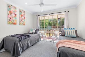 a bedroom with two beds and a couch and a window at Bells Rest with a view in Kurrajong