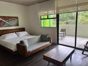 a bedroom with a bed and a couch and a table at BEE Suites Santa Ana in Santa Ana