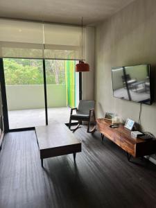 a living room with a coffee table and a chair at BEE Suites Santa Ana in Santa Ana