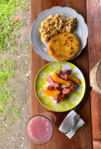 two plates of food on a wooden table with food at Popochos Beach Eco-Lodge in Nuquí