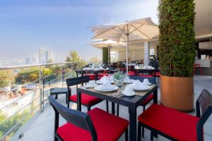 un restaurante con mesas y sillas en un balcón en Capitalia - ApartHotel - San Angel Inn, en Ciudad de México