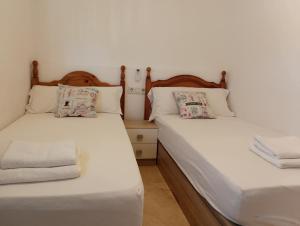 dwa łóżka ustawione obok siebie w pokoju w obiekcie Holiday Apartment Torres Montecarlo w mieście Benidorm +22 zdjęcia