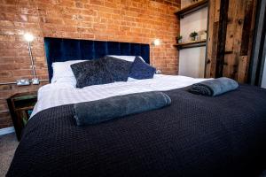 a bedroom with a bed with two pillows on it at VIP 3BR Grade2 Luxurious Industrial House with WOOD FIRE, Electric blinds and big Cast iron Windows in the heart of the JQ in Birmingham