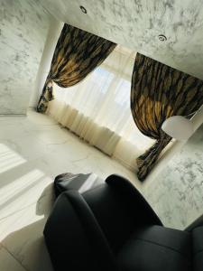 un soggiorno con divano e una grande finestra di GRAY APARTAMENT a Craiova