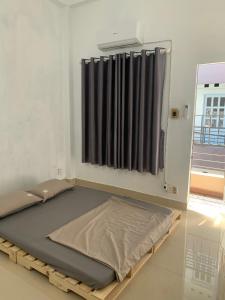 a bed in a room with a window at The Vinyl Homestay in Ho Chi Minh City