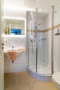 a bathroom with a shower and a sink and a toilet at Fischer Haus in Norderney