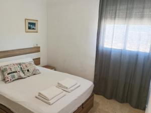małą sypialnię z łóżkiem z oknem w obiekcie Torres Montecarlo Apartmento con vistas al mar w mieście Benidorm