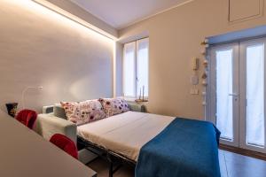 Un dormitorio con una cama y un sofá y una ventana. en Duomo a 2 fermate - Tiny Apartment in Pta Venezia, en Milán