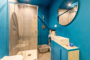 baño azul con ducha y lavamanos en Duomo a 2 fermate - Tiny Apartment in Pta Venezia, en Milán